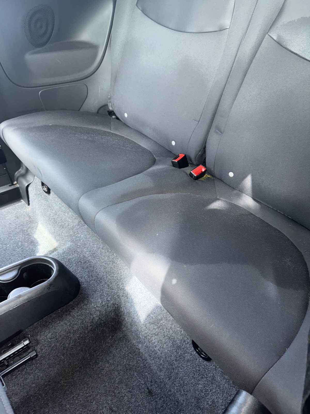 Dusty, mildewed compact-car back seat before detailing